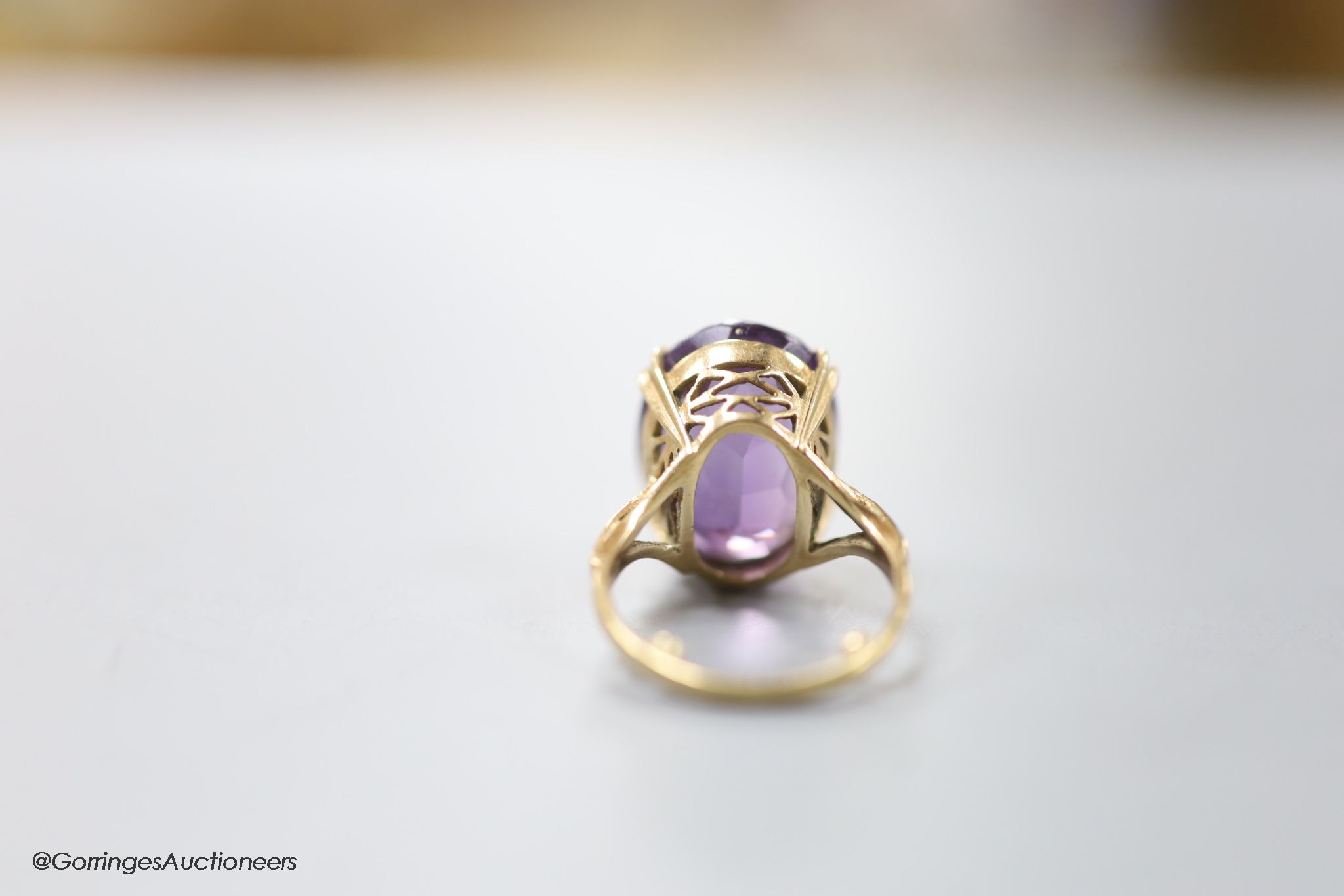 A 9ct gold and oval cut amethyst set dress ring, size H